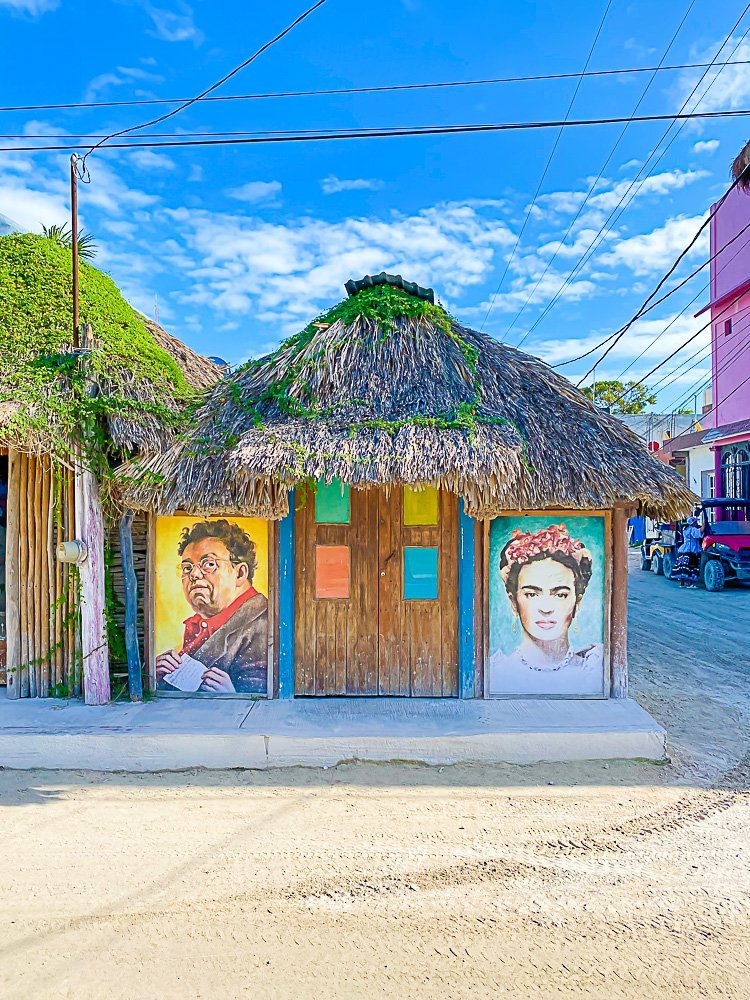 murals painted on doors of grass-roof building