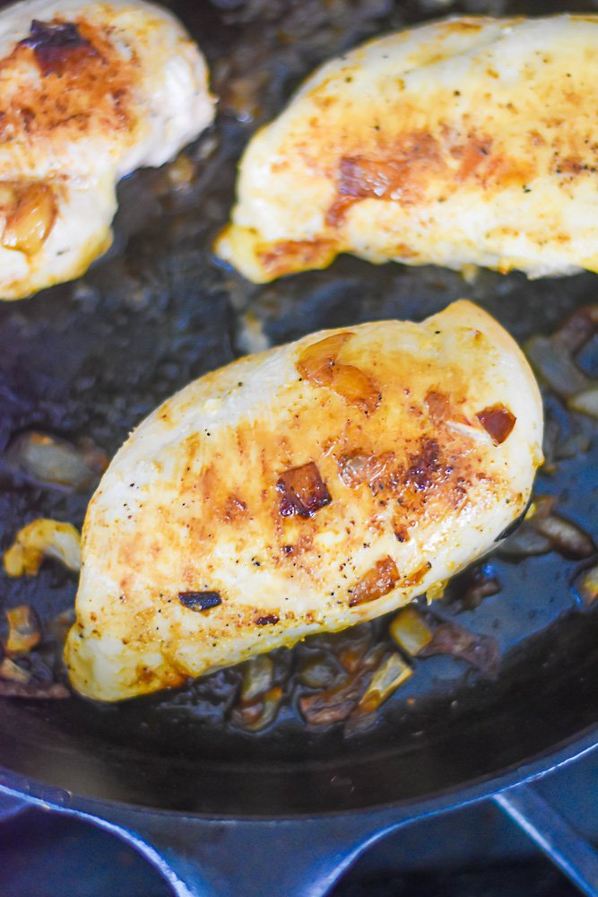 seasoned and cooked juicy chicken breast in cast iron skillet.