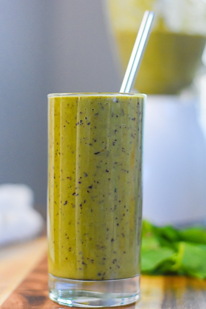 sweet green protein power smoothie in glass with metal straw