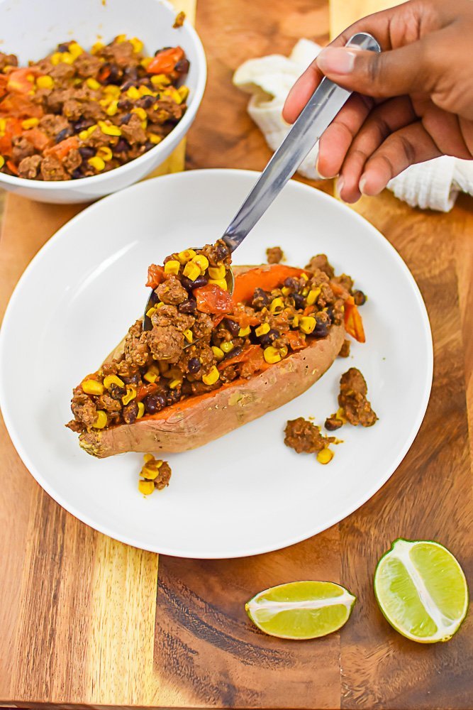 filling baked sweet potato with taco filling.