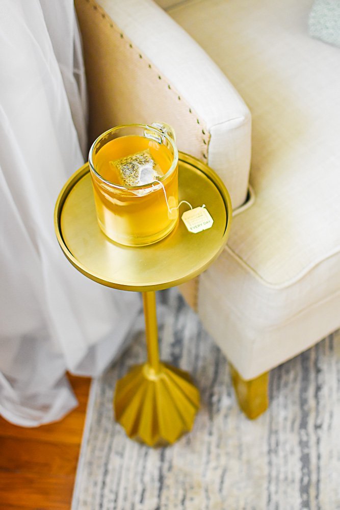 brass drink table with clear mug of tea sitting on top.