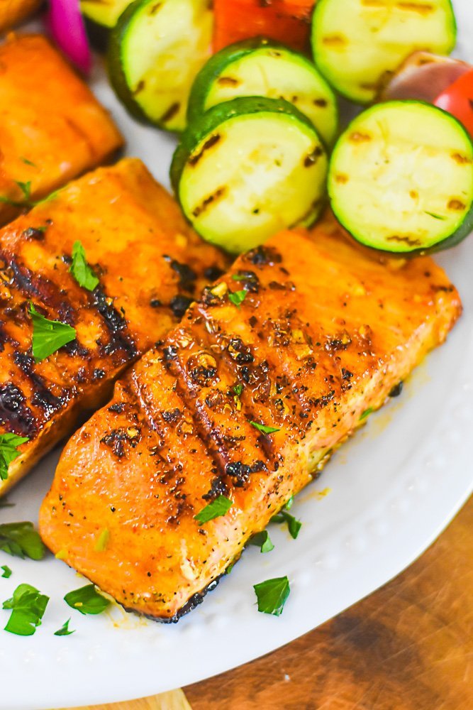 plate of grilled salmon filets with grilled zucchini and red pepper.
