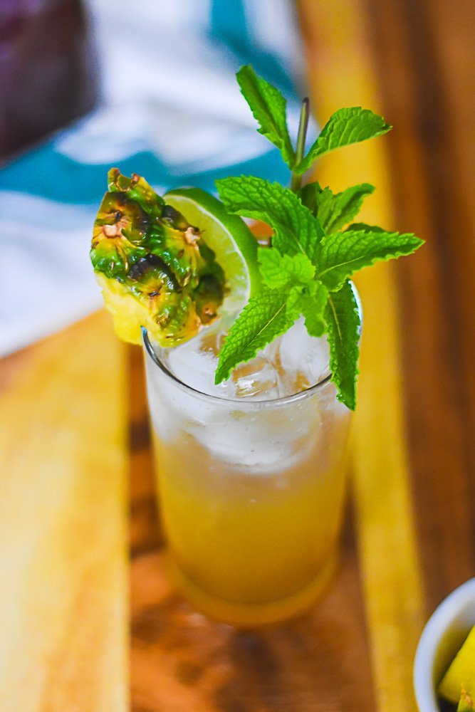 brown sugar pineapple mojito cocktail on wooden cutting board.