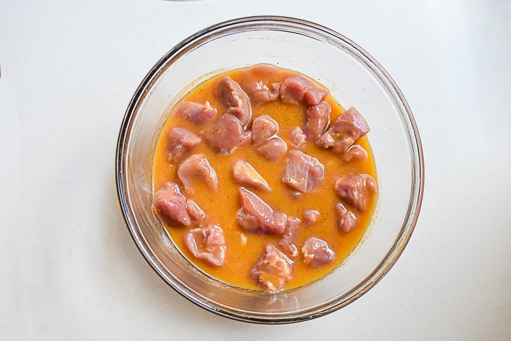 chunks of pork tenderloin marinating in peach habañero sauce.