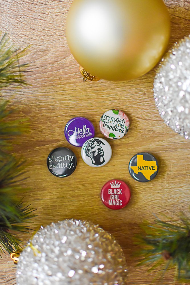 assortment of Inclusive Randomness buttons and Christmas tree ornaments.