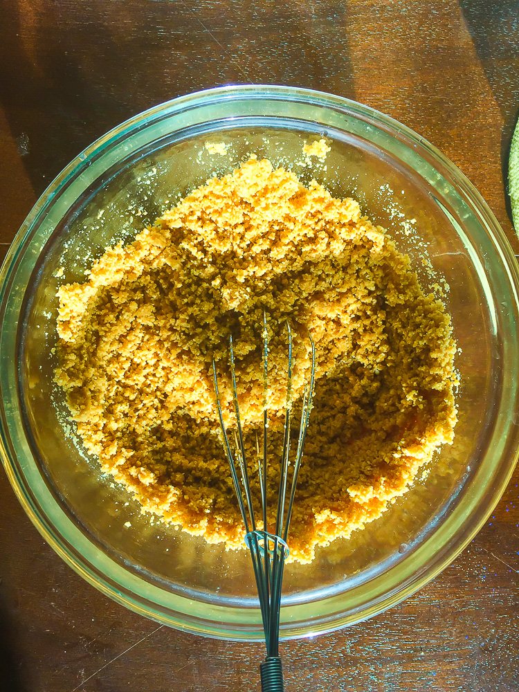 graham cracker crust ingredients in bowl with whisk.