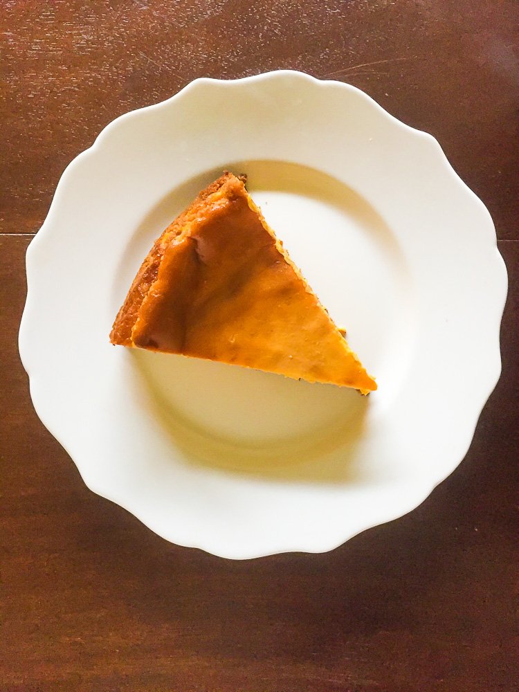 slice of pumpkin pie cheesecake on white plate.