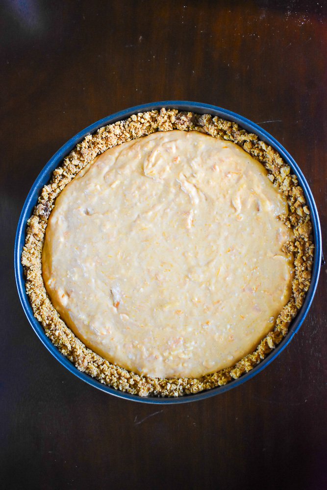 sweet potato cheesecake batter in crust ready for baking.