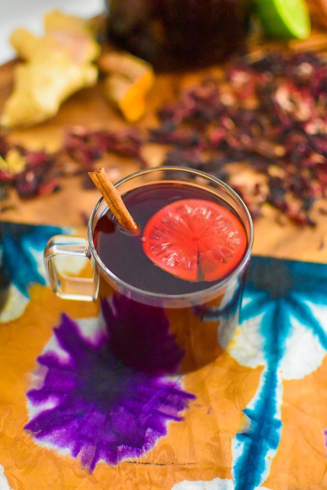 warm glass of zobo hibiscus tea on top of ankara fabric.