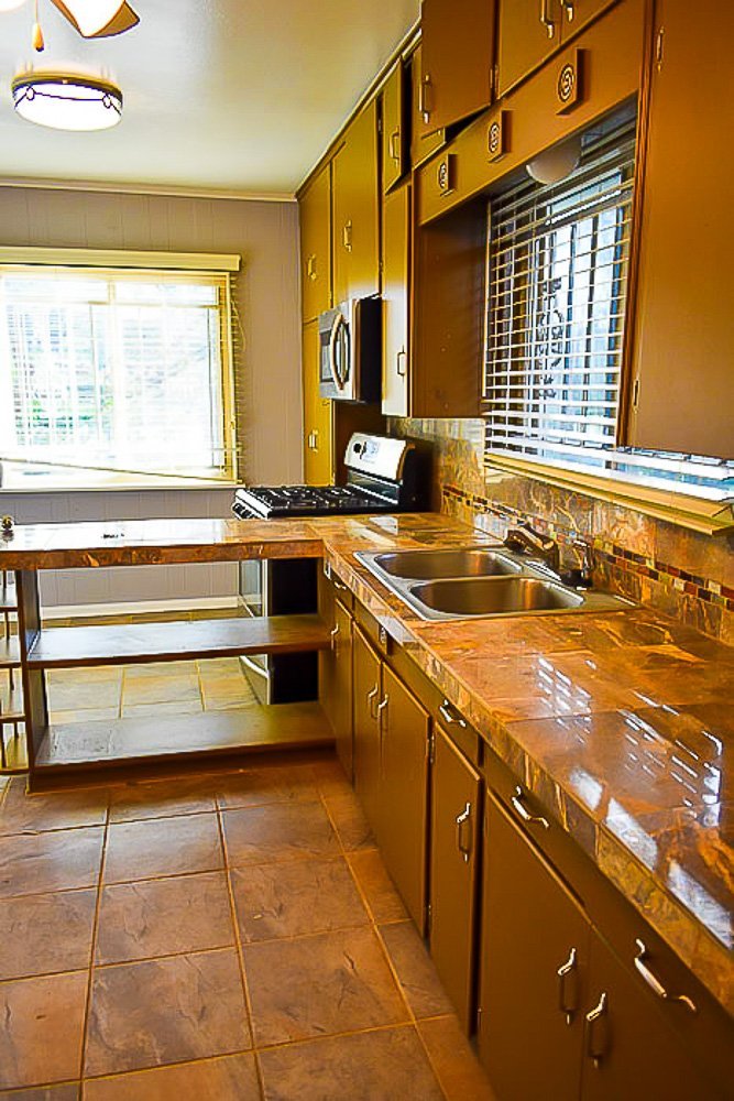 kitchen with brown cabinets and brown tile countertops.