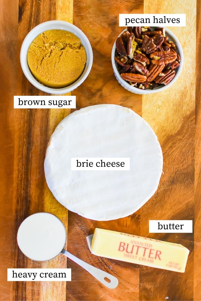 ingredients for pecan praline baked brie on wooden cutting board.