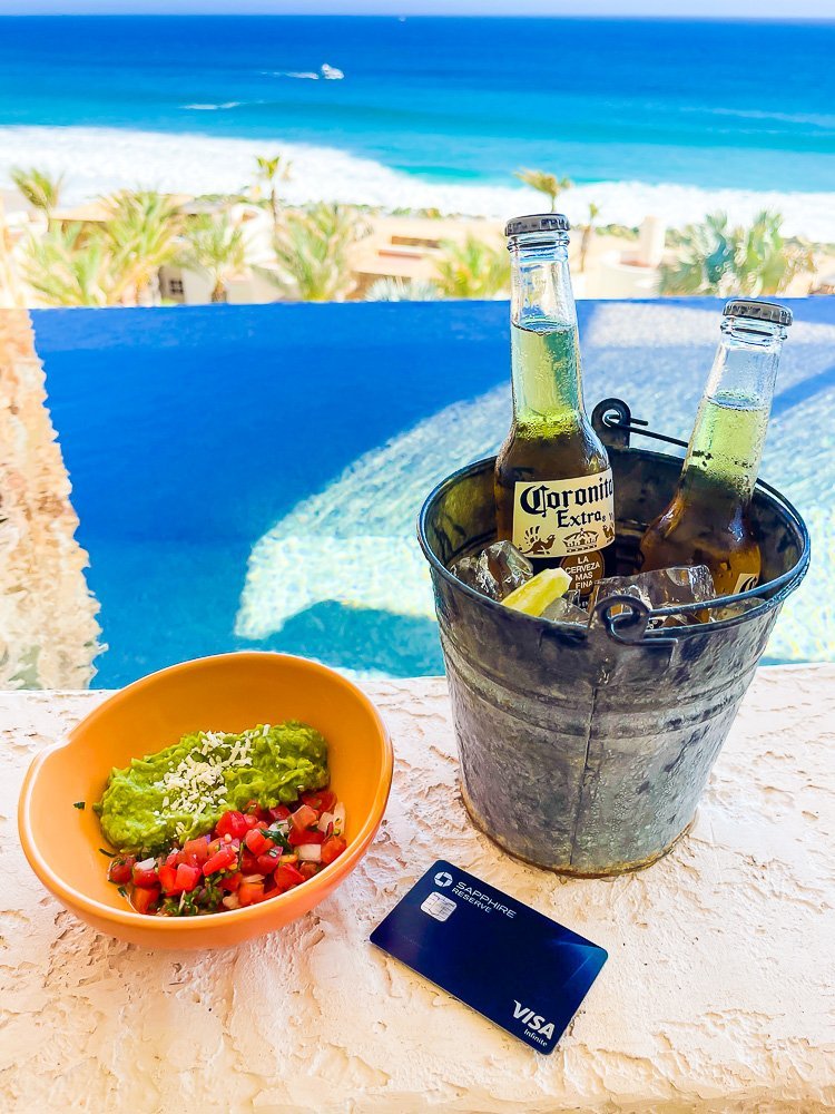 Chase Sapphire Reserve card next to bucket of beers on pool ledge.