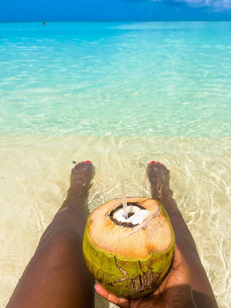 holding fresh coconut in shallow water.