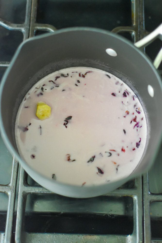 hibiscus tea latte in small saucepan on stove.