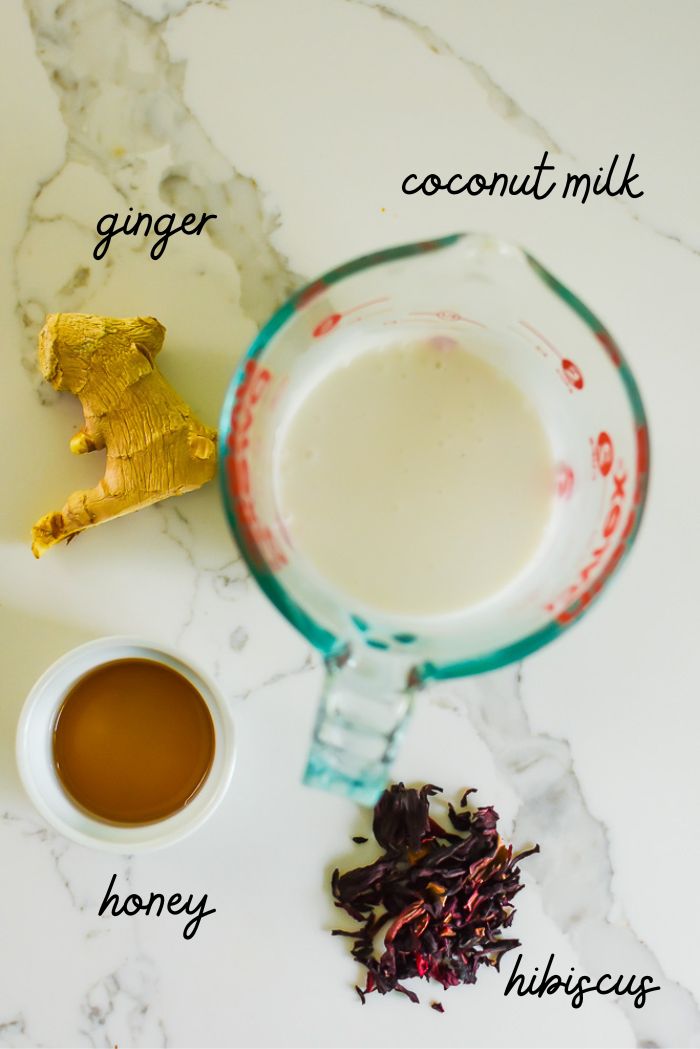 ginger, coconut milk, honey, and zobo petals on white granite countertop.