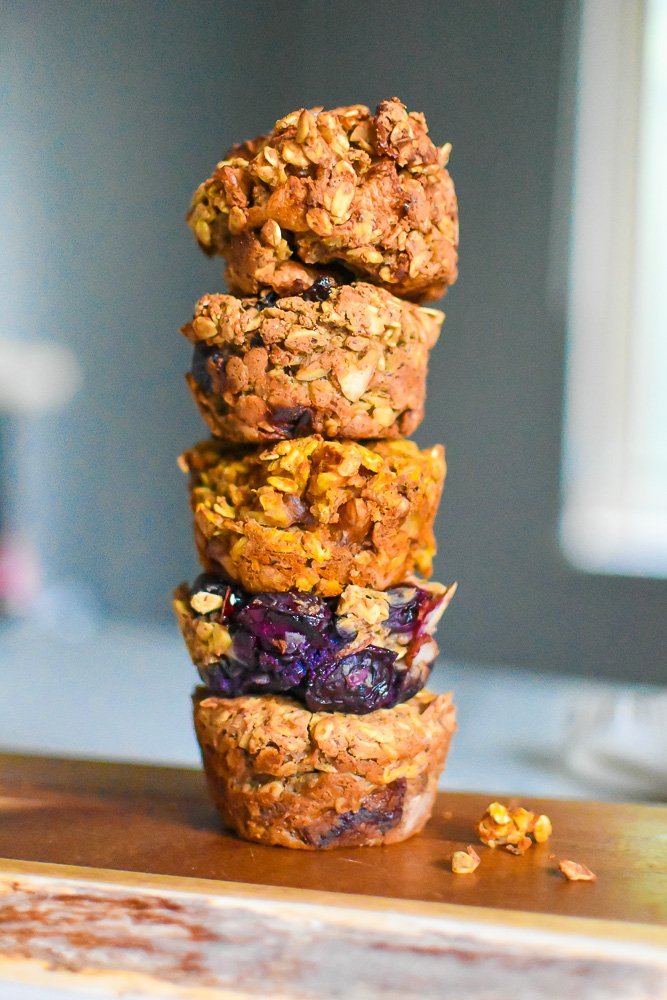 five flavored oatmeal cups stacked on top of each other on a wooden cutting board.