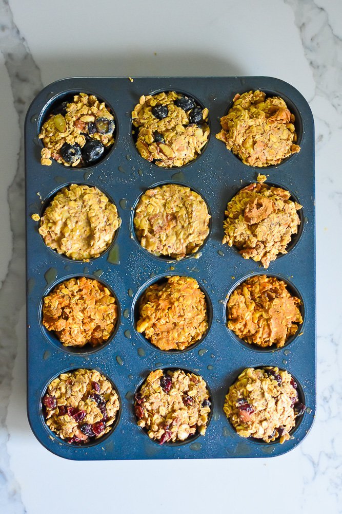 five different flavors of oatmeal protein cups in muffin pan prepared for baking.