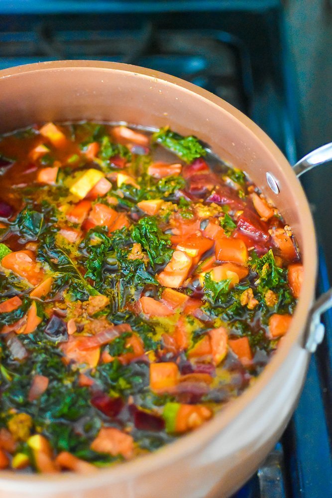 copper pot of rainbow soup with fall vegetables.