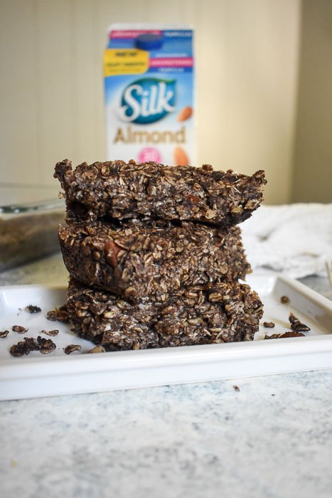 stack of three chocolate oatmeal bars on white plate for breakfast.