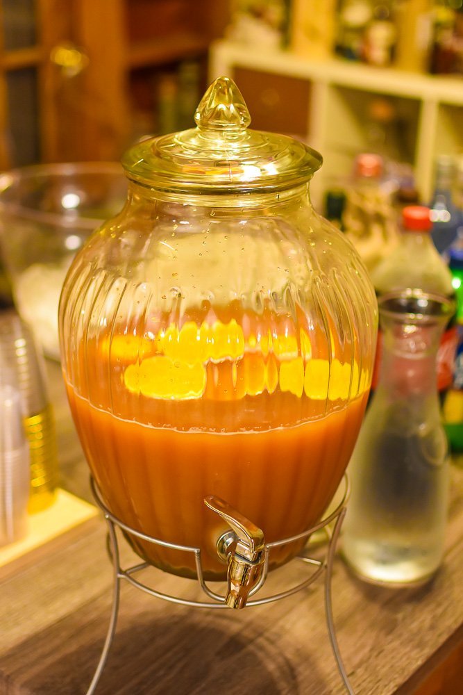 cranberry apple cider punch in glass dispenser.