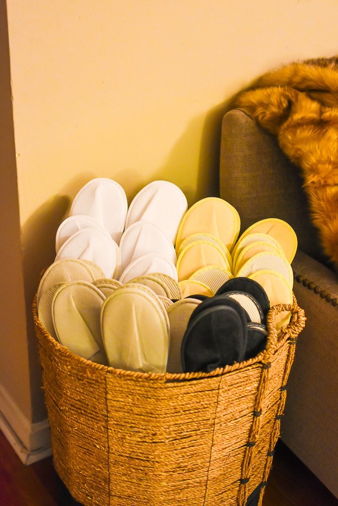 disposable slippers for houseguests arranged in wicker basket.
