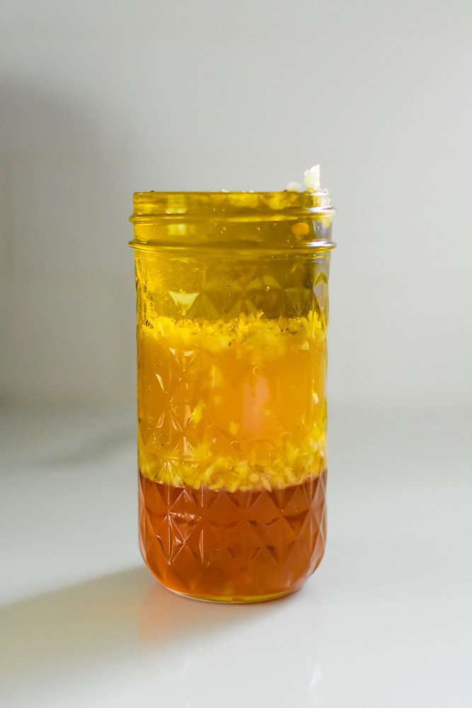 layers of oil, vinegar, and honey in a jar.