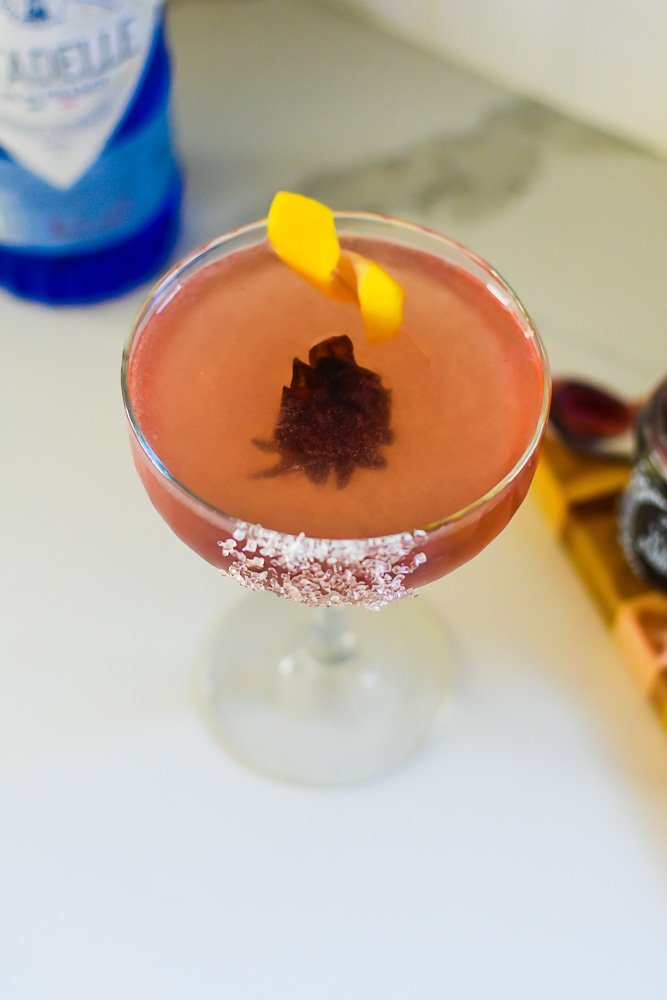 pink hibiscus French 75 cocktail in champagne cocktail glass.