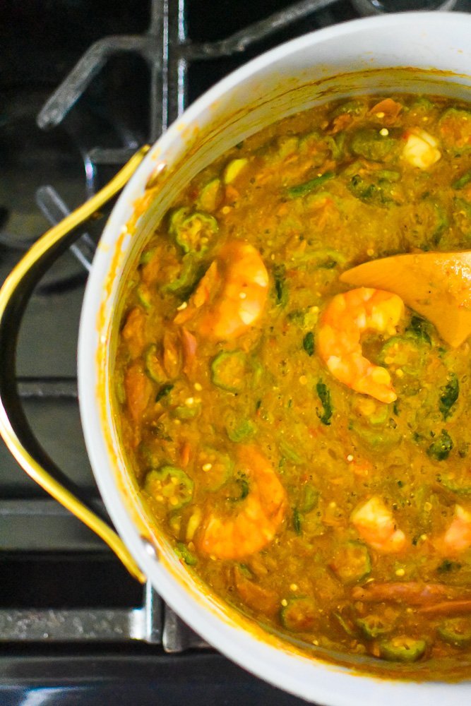 finished pot of Nigerian okro soup with large prawns and okra slices on top.
