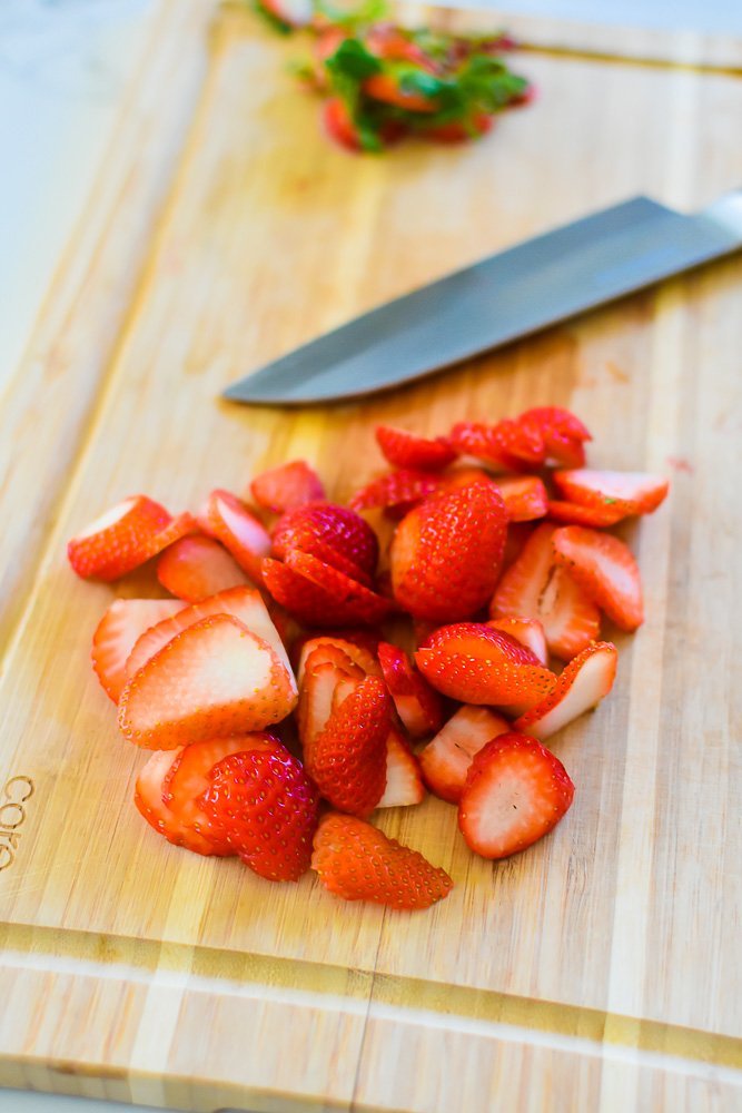 sliced strawberries on cutting board.