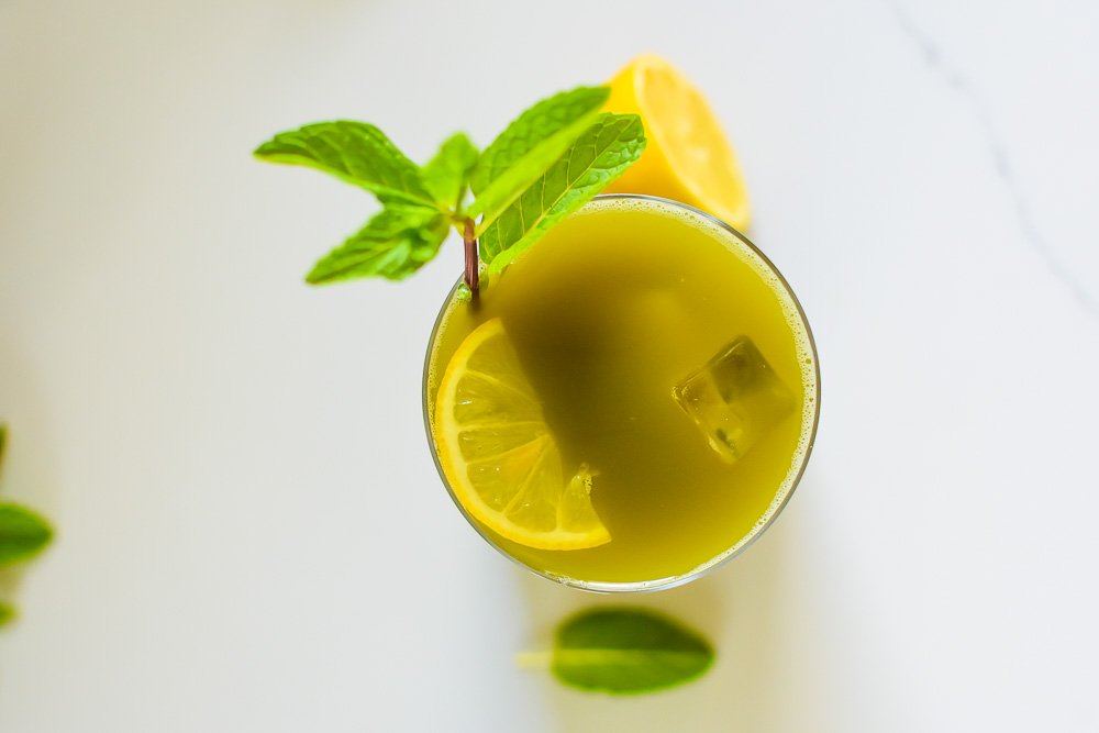 mint matcha iced tea with half slice of lemon floating on top.