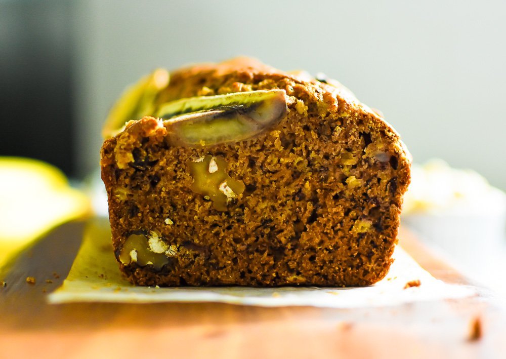slice of chai banana nut bread with walnuts dispersed evenly through the bread.