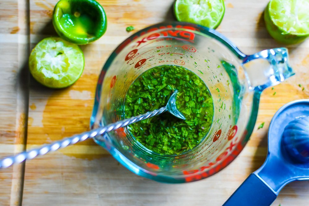 fresh lime juice, honey, and chopped mint leaves mixed up in glass measuring cup.
