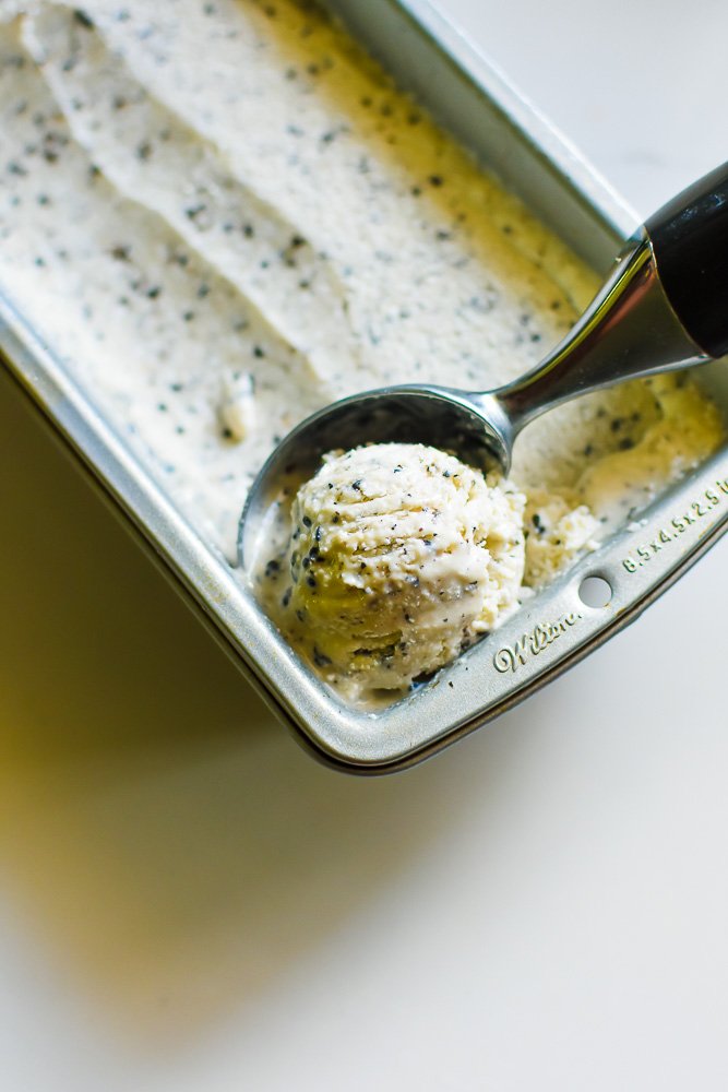 scooping black sesame ice cream out of loaf pan.