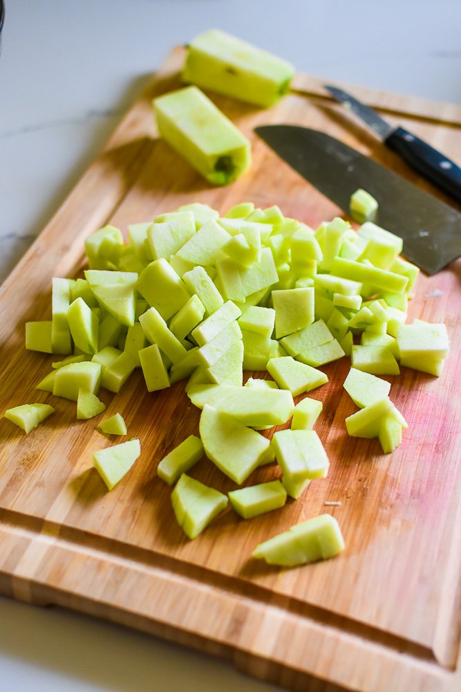 peeled and diced Granny Smith apples on wooden cutting board.