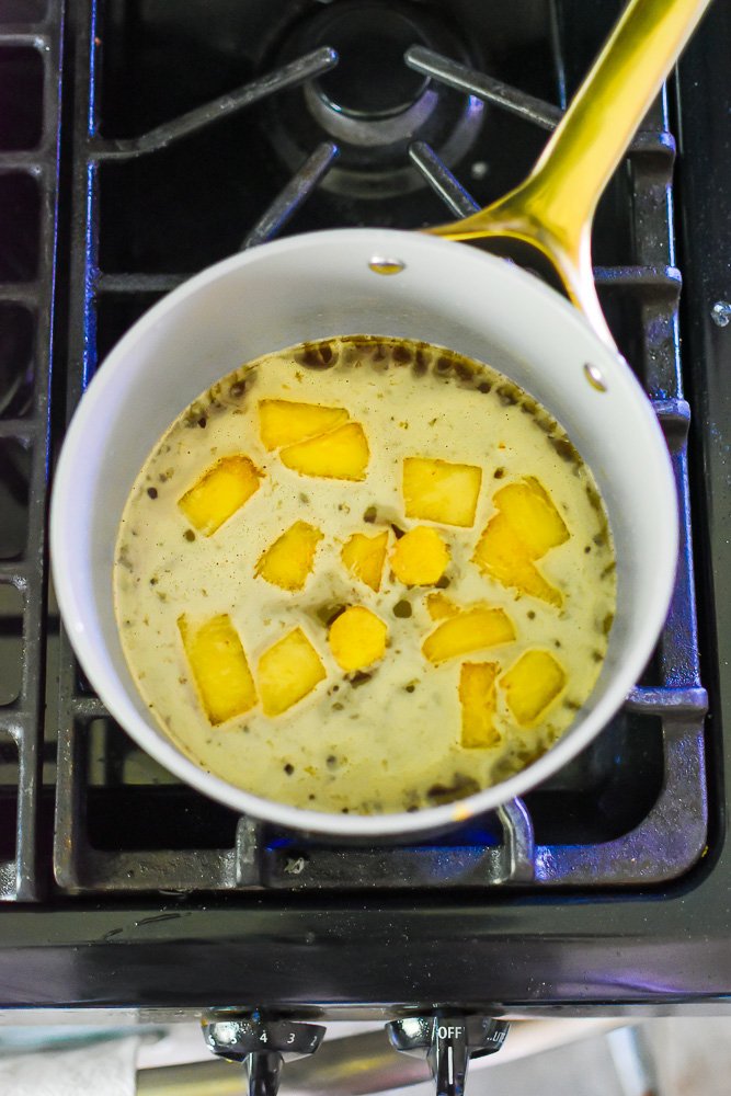 cooking down pineapple, pineapple juice, ginger, and brown sugar in a small saucepan.