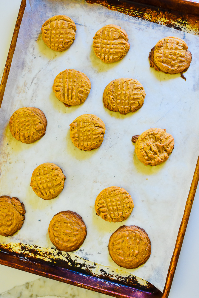 baked chai and peanut butter cookies on parchment lined cookie sheet.