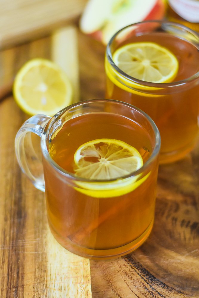 easy spiced apple cider hot toddies with whiskey in clear glass mugs.