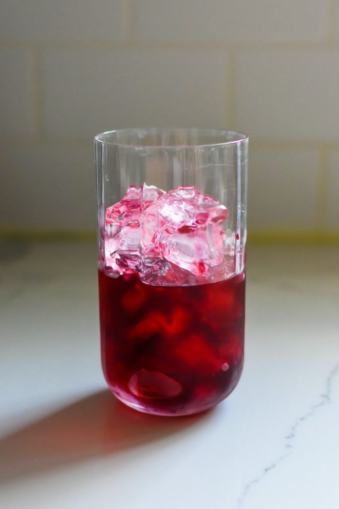 highball glass ¾ full with ice, three ounces gin, and two ounces hibiscus tea.