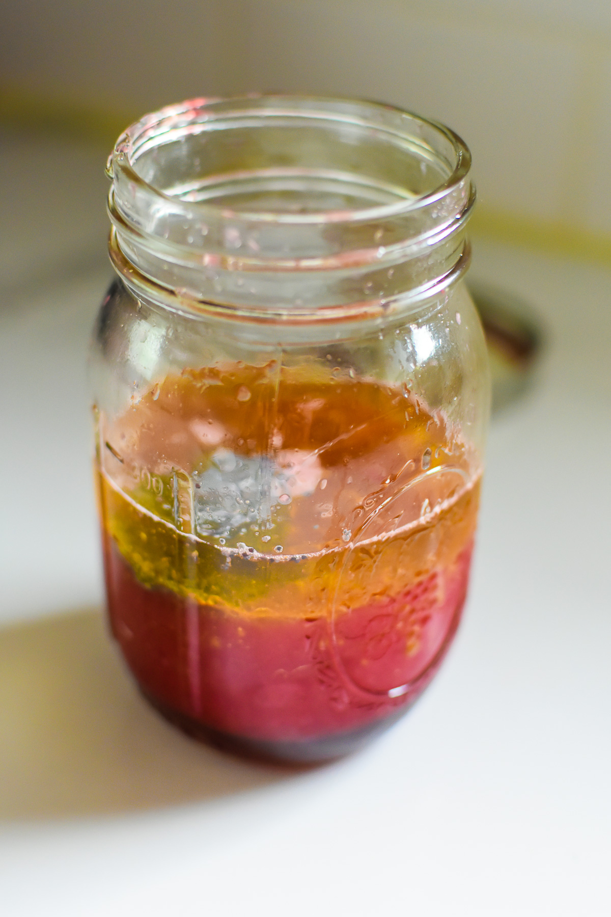 ingredients to make fresh blood orange juice vinaigrette in mason jar.