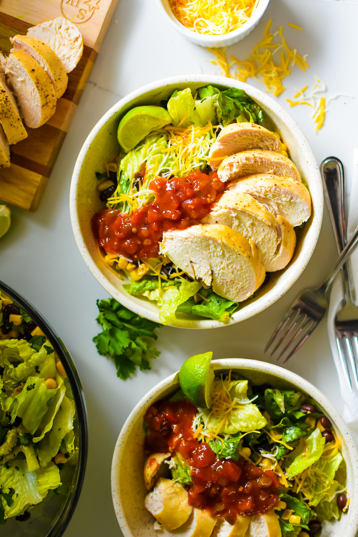 two chopped southwest salad bowls filled with lime marinated chicken, spicy salsa, chopped romaine, and more.