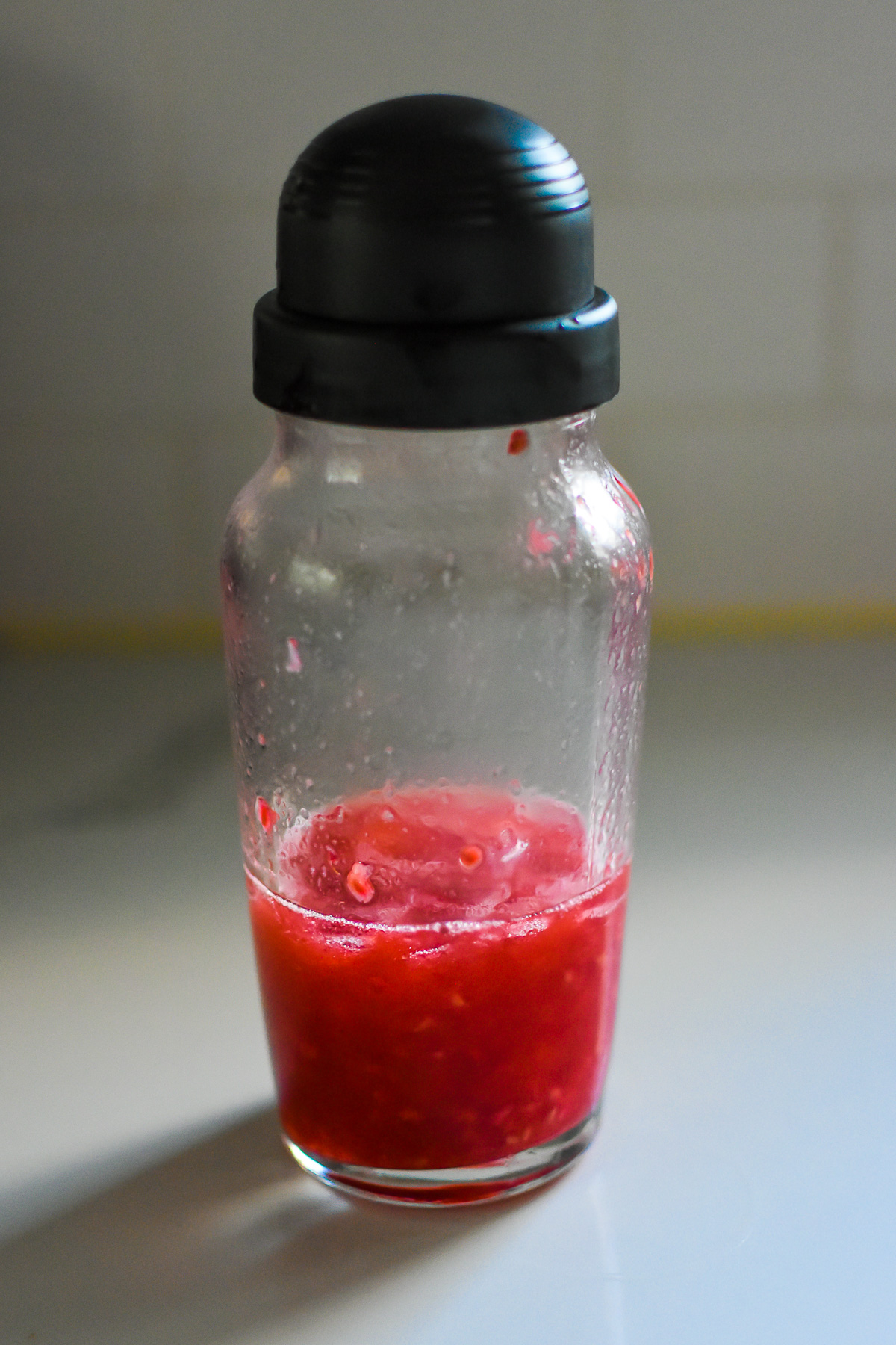 raspberry chambord martini ingredients shaken over ice in cocktail shaker.