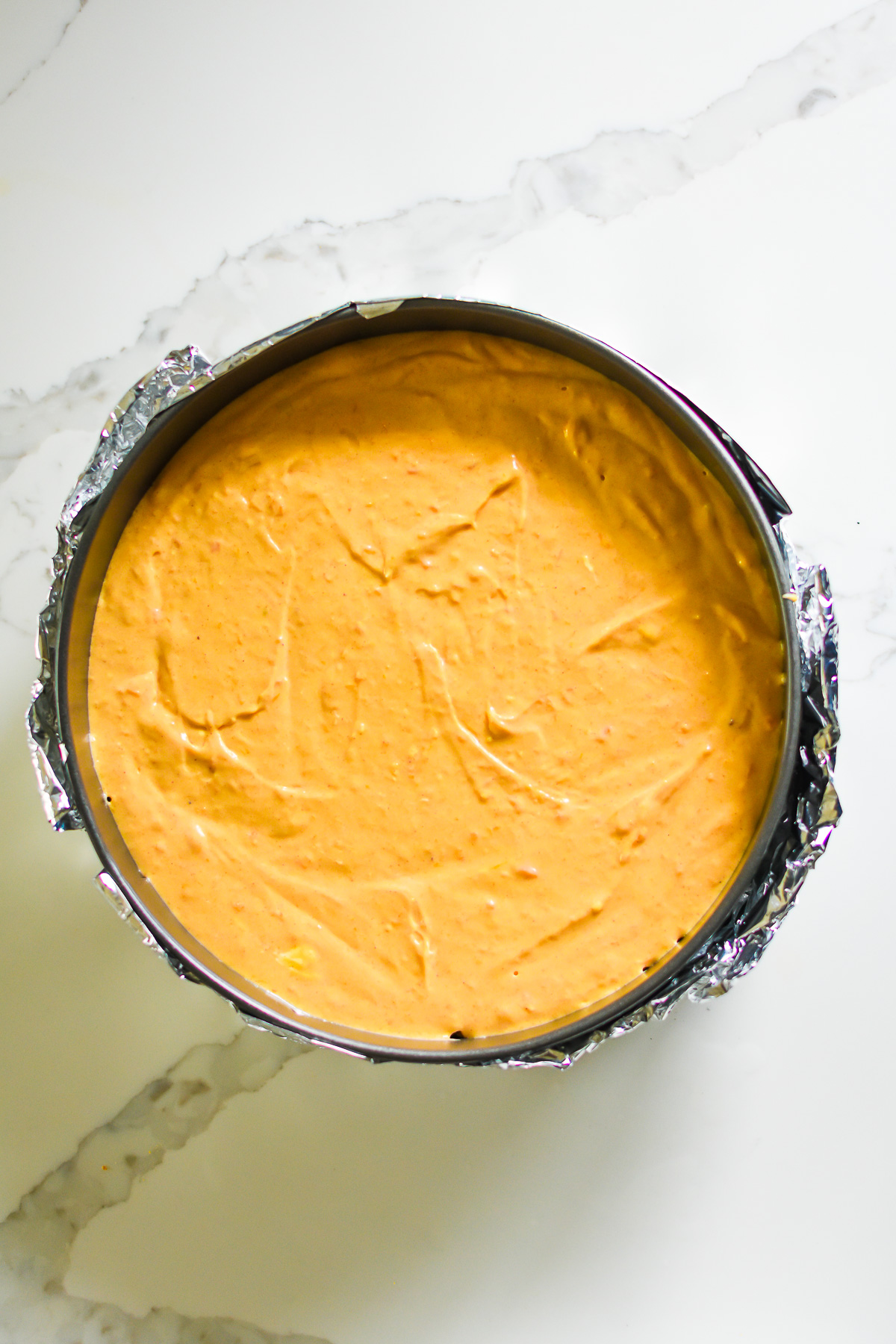 unbaked sweet potato pie cheesecake in foil wrapped springform pan.