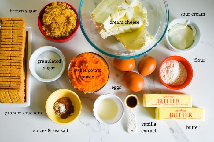 ingredients to make the best sweet potato cheesecake on granite counter top, including softened cream cheese, sweet potato puree, brown sugar, and sour cream.