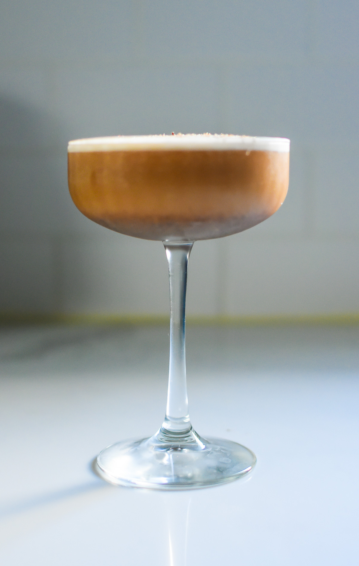 creamy chai latte martini strained into frosted coupe glass with layer of foam on top.