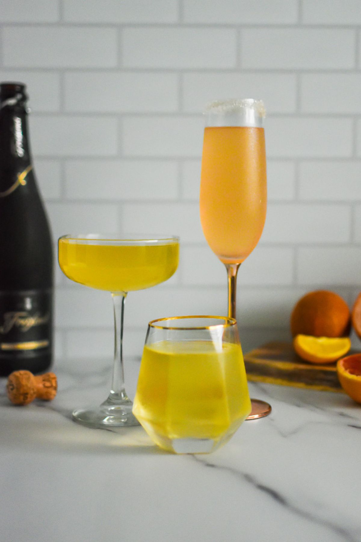 easy citrus champagne cocktails made with different flavored citrus syrups and sparkling wine in festive glasses for celebrating New Year's Eve.