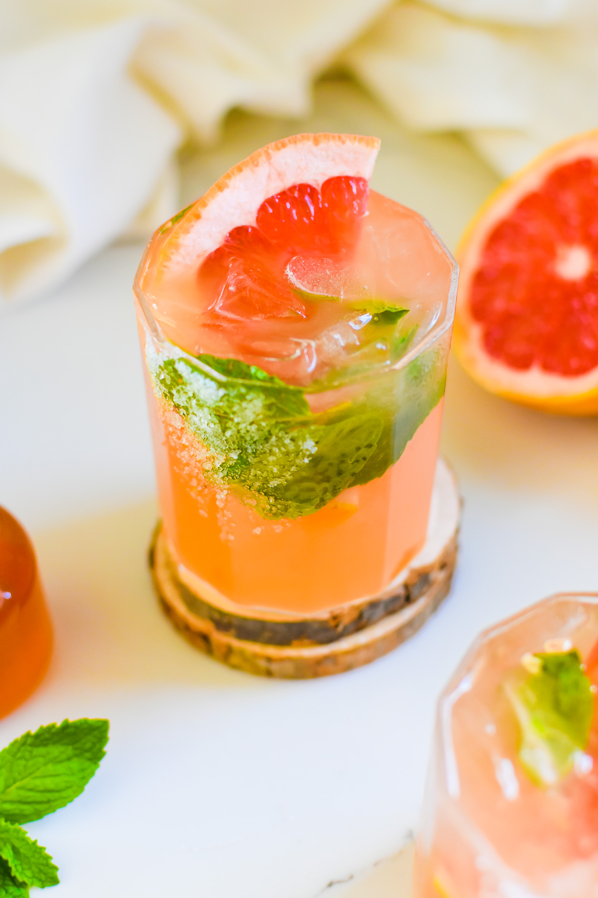 the best easy homemade grapefruit shrub mocktail garnished with fresh mint leaves and slice of grapefruit in a rocks glass.