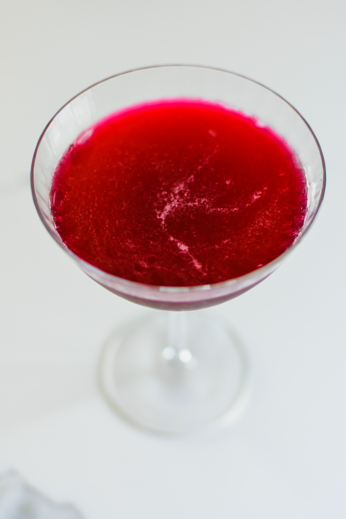 homemade hibiscus flavored martini in ribbed couple glass.