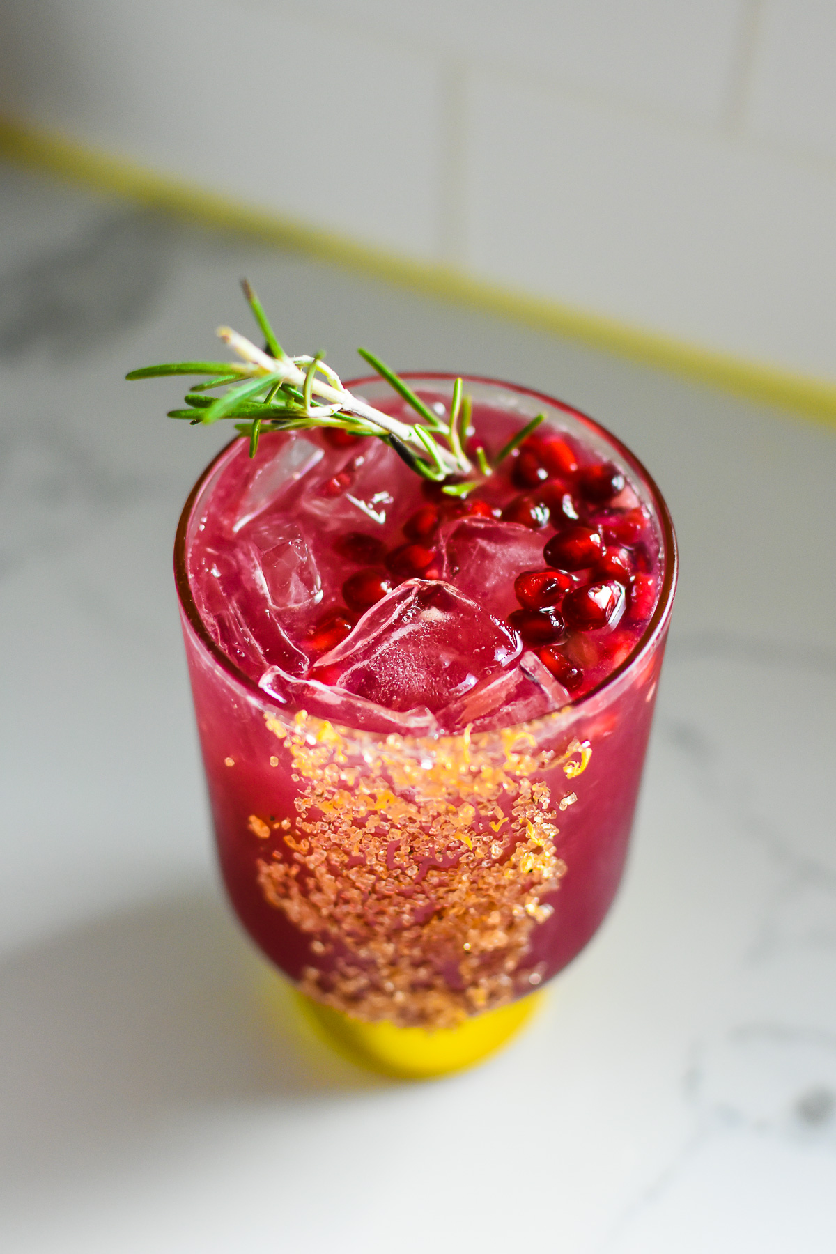 quality Christmas mocktail garnished with pomegranate seeds and fresh rosemary.