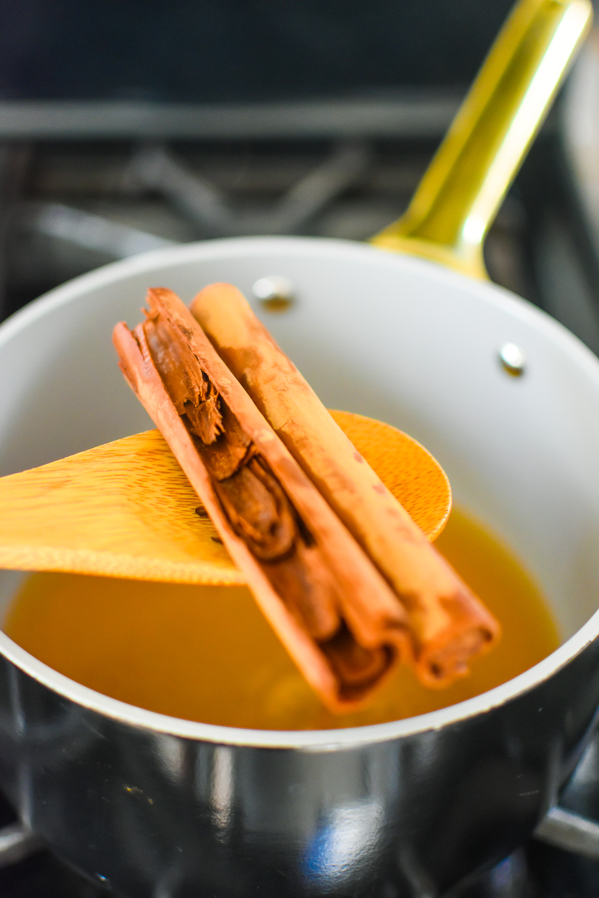 scooping out cinnamon sticks from hot cinnamon infused water.