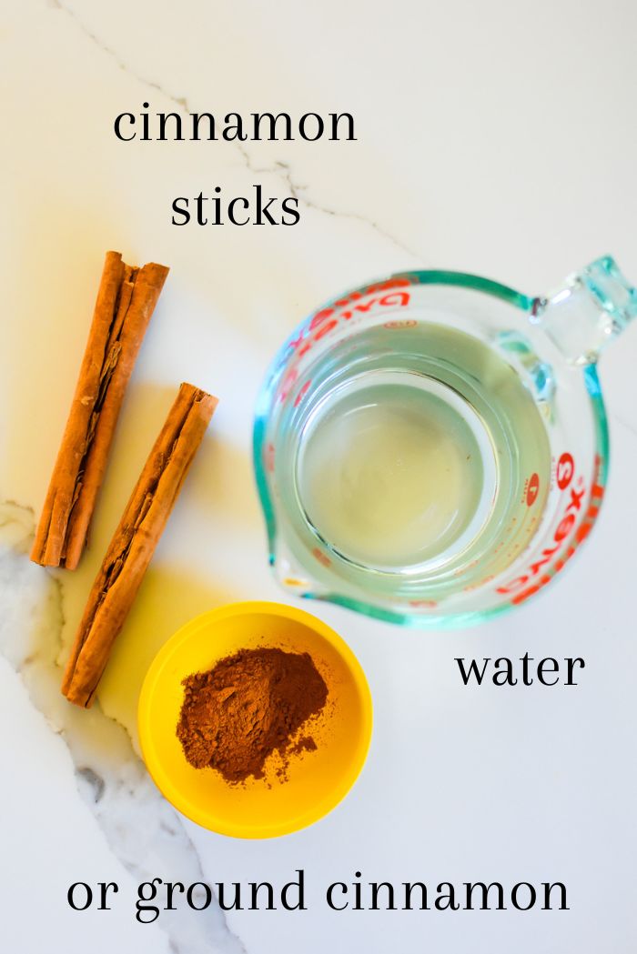 ingredients to prepare cinnamon tea at home on granite countertop, including filtered water, natural Ceylon cinnamon sticks, and organic Ceylon cinnamon powder. 